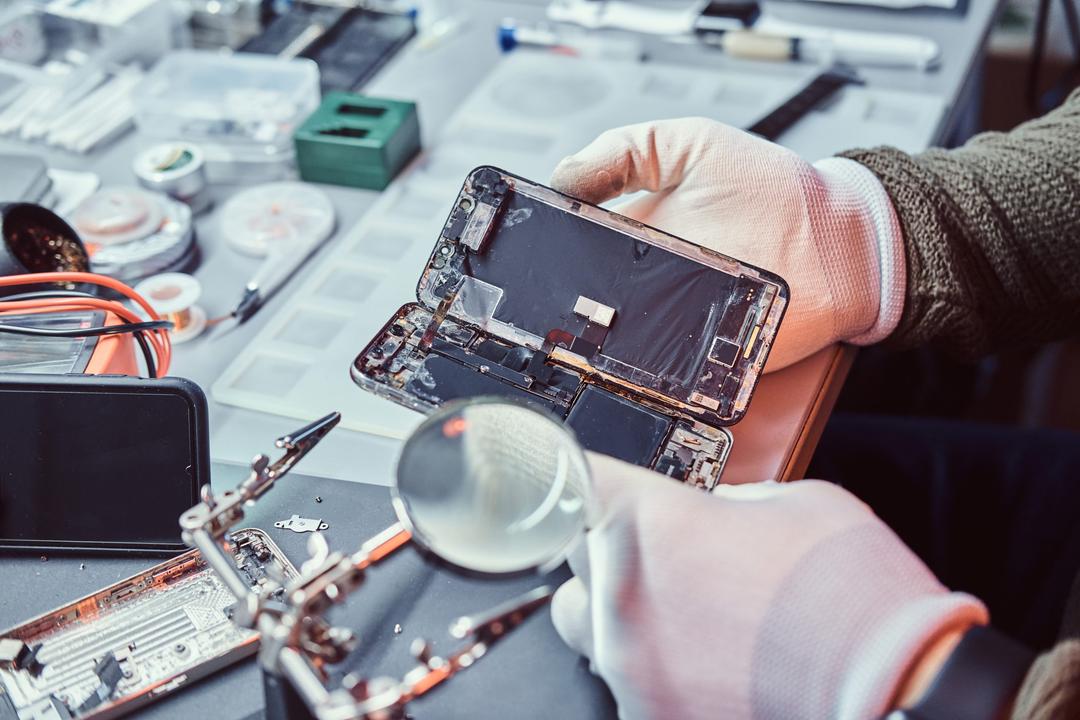 Cell Universe technician inspecting the internal parts of a phone